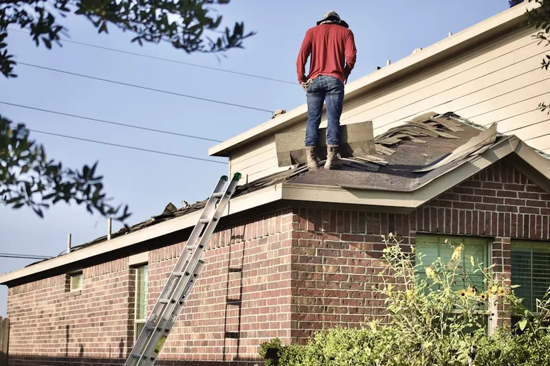 Professional roofer working on a residential roof in Ewing